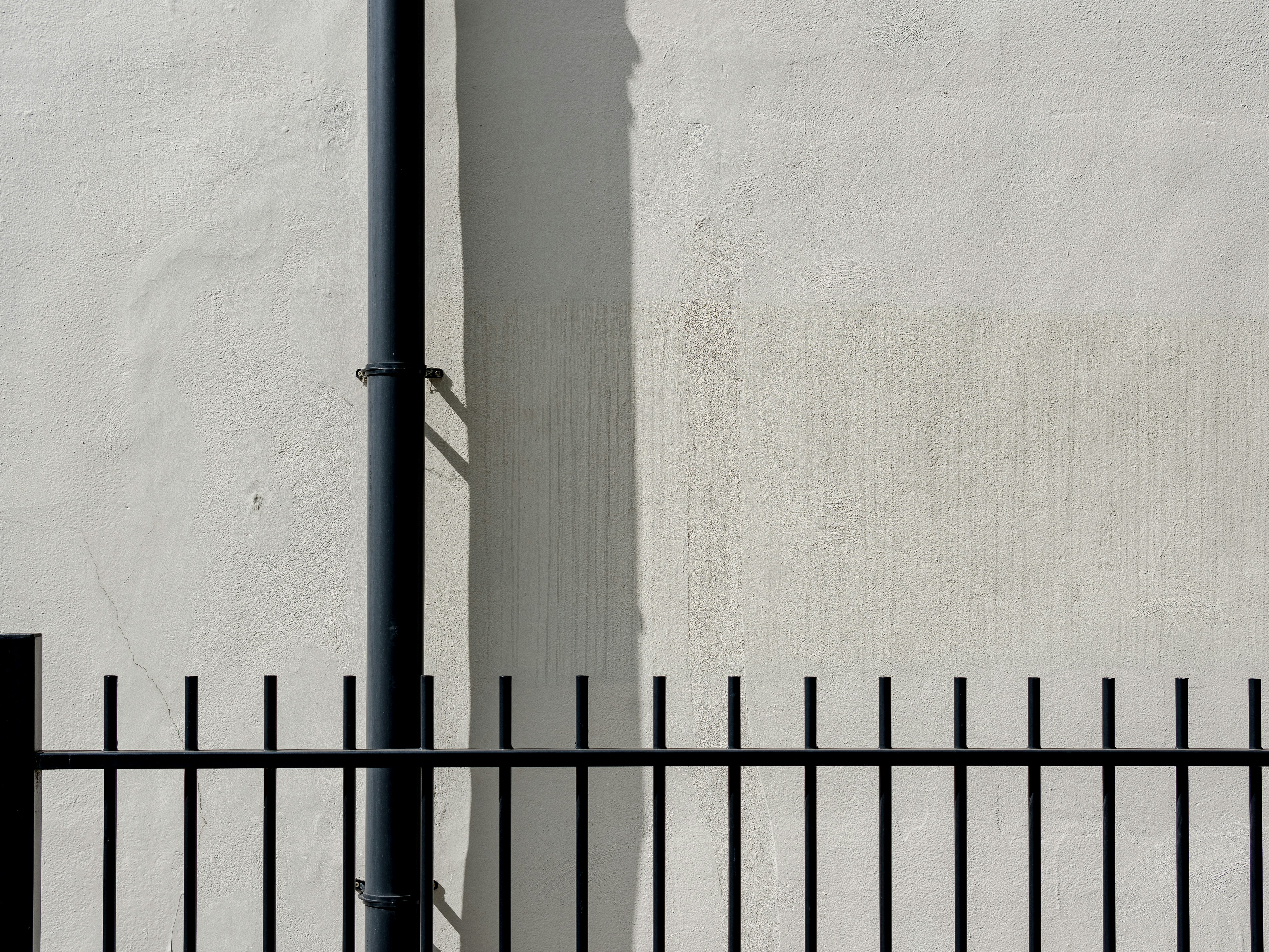 black metal fence near white wall